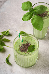 Spinach smoothie healthy green. Vegan smoothie or milkshake from spinach, banana and chia seeds on gray concrete table background. Clean eating, alkaline diet. Top view. Mock up.