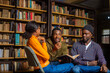 © Vic Josh - happy young university students studying with books in library.