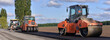 roller laying fresh asphalt . Road works with excavators. Construction of new roads on the highway in the field 