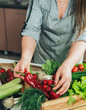 © Tijana - Close Up Photo of Woman Hands Taking Fresh Vegetables from a Wooden Crate in the Kitchen