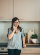 © Tijana - Smiling Business Woman Talking on a Mobile Phone in the Kitchen