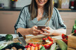 © Tijana - Close Up Photo of Woman Hands Using Mobile Phone while Making Healthy Lunch in the Kitchen