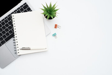 Wall Mural - Blank white notepad on laptop computer with stationery on white table desk background with copy space,Flat lay, work space, minimal work 