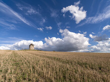 Windmill In A Cropped Field With A Blue Sky With White Clouds, Normandy, France