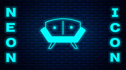 Sticker - Glowing neon Sofa icon isolated on brick wall background. Vector