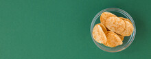 Potato Chips In Glass Bowl On Green Background. Fast Food.