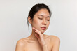 © Prostock-studio - Naked sensual korean lady touching her face and enjoying silky touch after using nourishing cream, white background