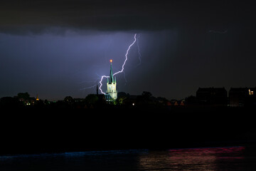Wall Mural - lightning bolt strikes behind a church near a river