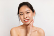 © Prostock-studio - Closeup of sensual asian lady with glow and smooth skin posing on white studio background and smiling at camera