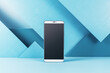 © Who is Danny - Close up of blank cellular phone screen on blue geometric wall background. Tech presentation and device concept. Mock up, 3D Rendering.