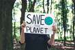 © puhimec - Poster in the call to save the planet in female hands in the forest.