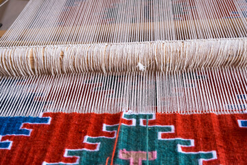 Detail of loom for weaving traditional handmade carpets, rugs.  Weaving and manufacturing of Turkish style homemade carpets. Selective focus.