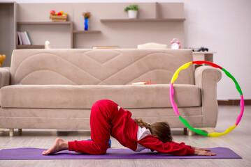 Young little girl doing sport exercises at home