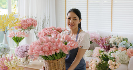 Wall Mural - Asia people young woman SME owner happy smile look at camera greeting enjoy open flower shop work at home office workspace. Loan money banking for online store seller. Girl power pride in sale order.