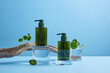 Front view of centella asiatica decorated with cosmetic jar and transparent podium cosmetic jar branch tree in blue background 