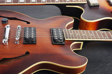 Wall Mural - Two jazz electric guitars on a dark background. Close up.