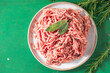 Raw Mince, minced Ground beef meat on a cutting board. Green background. Top view