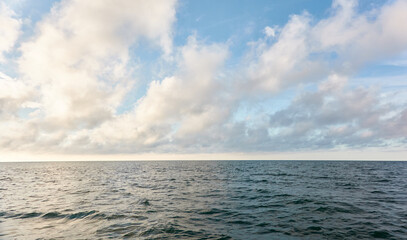 Wall Mural - Panoramic view from the Baltic sea shore after the storm. Clear sunset sky, reflections, still water surface texture. Nature, environment. Idyllic dreamlike seascape