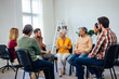 © bnenin - A wide ankle of people attends the group therapy, talking to each other.