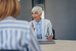 © bnenin - Portrait of a focused businesswoman, working as an insurance agent, talking with clients.