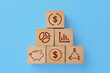 © New Africa - Pyramid made of wooden cubes with different images on light blue background, flat lay. Management concept