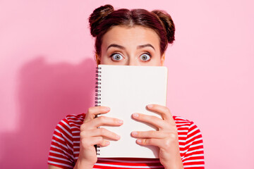 Poster - Photo of puzzled person hold notepad close hide face isolated on pink color background