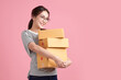 © kitthanes - Beautiful Young Asian woman holding parcel box isolated on pink background, Delivery courier and shipping service concept.