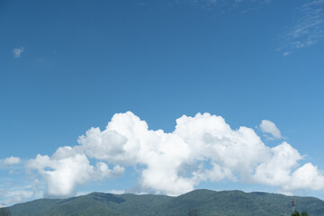 Wall Mural - the white clouds have a strange shape and moutain.the sky and the open space have mountains below.
