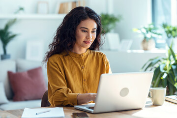 concentrated business woman working with laptop in living room at home.