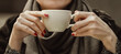 Close up woman hands with red manicure holding coffee cup, vintage toned