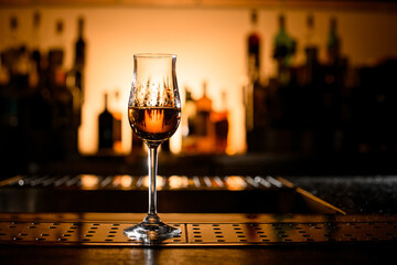 beautiful view on clear stemware of alcoholic drink on bar counter.