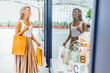 © Jelena Stanojkovic - Young women looking at the kids shop in the shopping mall. happy woman with shopping bags at the mall.