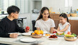 © supAVADEE BUTRADEE - The family has father, mother and Asian daughters sitting at the dining table, finished cooking in the kitchen, and having breakfast together in the dining room at home.