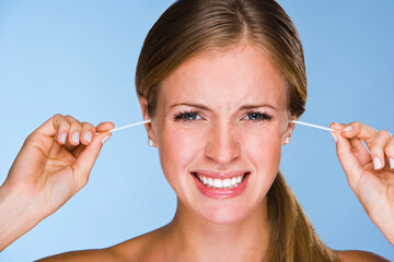 Wall Mural - Woman plugging ears with cotton swabs