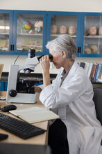 Female Scientist Using Microscope In Laboratory