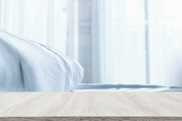 Wall Mural - Wooden table and blurred bedroom background, bright morning light. Product display or mock up