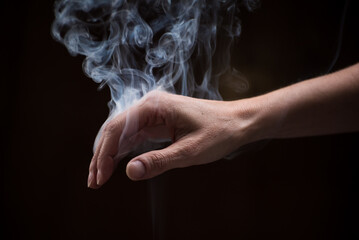  hand down with smoke between the fingers, harmony concept