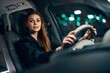 © SHOTPRIME STUDIO - a happy, joyful woman is sitting behind the wheel of a car with a seat belt fastened and smiling happily looking at the camera