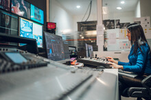Middle Aged Woman Using Equipment In Control Room On A Tv Station