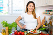 Young colombian housewoman cooking vegetable salad at home kitchen