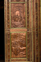 Hand made copper engraved doors on the entrance of the Basilica of Sainte-Anne-de-Beaupre depicting life of Jesus, Cathedral, Quebec an Catholic sanctuary. The shrine is known as a place of miracles.