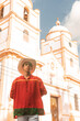 Latin teenager with classic clothes and hat from Nicaragua and the traditional dance from Latin America in front of the cathedral church of Jinotega