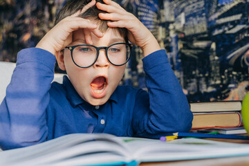 Exhausted cute tired teen schooler boy wearing eyeglasses yawning studying suffering from eye strain write homework study at home, get ready exam, stressed difficult task, reading book. Home education