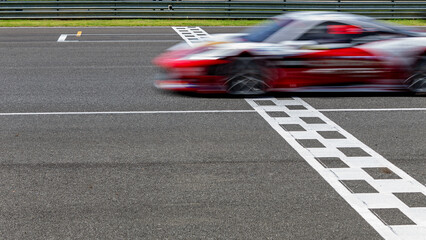 Race car blurred motion crossing the finish line on international circuit speed track, Motion blur Racing car crossing finish line on asphalt main straight racetrack.