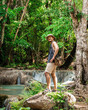 © Tony - Thai guy Asian man backpacker men enjoying on beautiful emerald waterfalls green forest mountains guiding for Thailand destinations camping hiking at Erawan waterfall national park, Kanchanaburi.