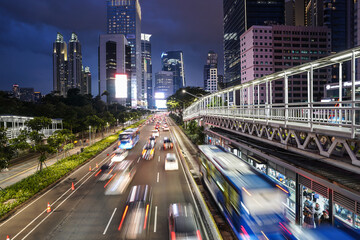 Wall Mural - Jakarta, Indonesia: Traffic captured with blurred motion rushes on the Jakarta business district at dusk in the modern Indonesia capital city