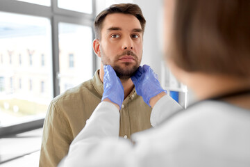 Poster - medicine, healthcare and people concept - female doctor checking lymph nodes of man patient at hospital