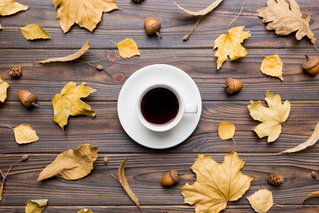 Wall Mural - flat lay composition with colorful autumn cup of coffee and leaves on a color background. top view