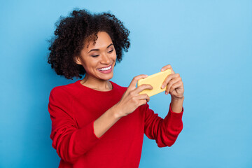 Photo of charming cute young woman wear red sweater tacking photo device empty space isolated blue color background