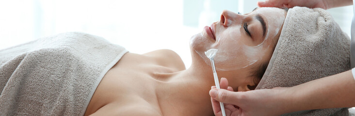 Poster - Cosmetologist applying mask on client's face in spa salon. Banner design